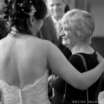 Bride talks with her new second mom while the groom looks on in the background in Winchester Town Hall in Winchester, MA.