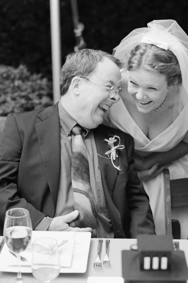 bride laughs hard with her dad at reception